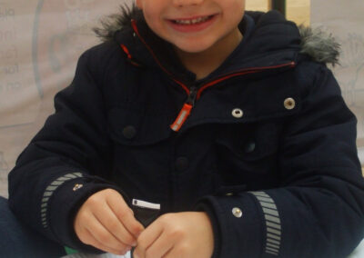 Boy decorating a yummy cookie with icing on a white plate