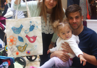 Family with a child showing off a decorated tote bag in Uxbridge.