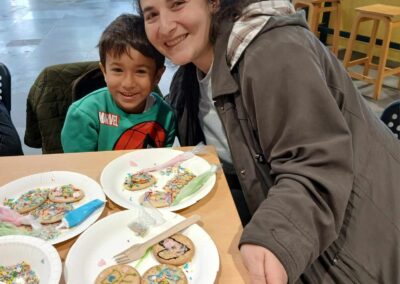 Mom and child decorating cookies with sprinkles. Fun family activity.