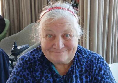 Enthusiastic senior woman wearing Union Jack headband, celebrating a patriotic event.