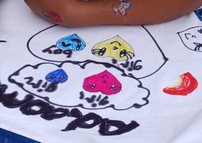 Child coloring a white pillowcase with "Addam" written on it, featuring colorful heart designs labeled "boy" and "girl.