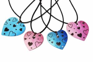 Ombre heart necklaces in blue and pink with black heart designs on black cords.